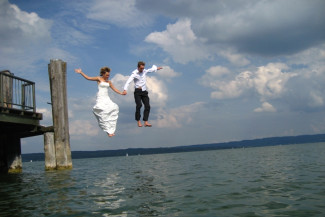 Ein Brautpaar springt in einen See