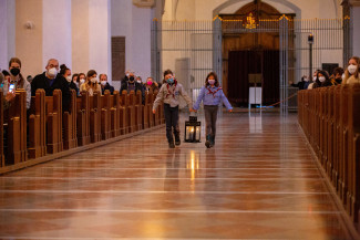 Zwei junge Pfadfinder:innen tragen das Friedenslicht aus Bethlehem in die Münchner Liebfrauenkirche (Robert Kiderle Fotoagentur)