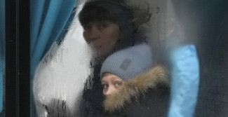 Ein Kind aus der Ukraine sieht durch ein beschlagenes Busfenster